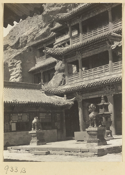 Facade of a three-story temple building and courtyard with animal statues and incense burner at the Yun'gang Caves