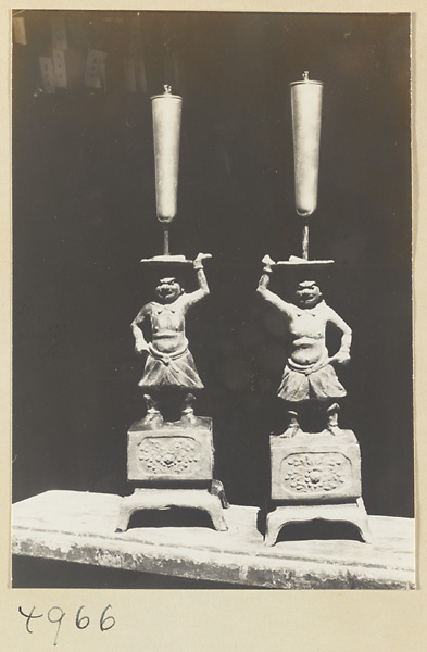 Two candlesticks with male caryatid figures in a Daoist temple on Hua Mountain