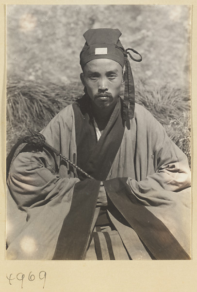 Daoist priest wearing formal dress and holding a yak-tail fly whisk on Hua Mountain