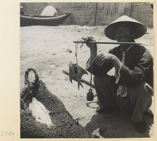 Fish vendor weighing a pomfret in a village on the Shandong coast