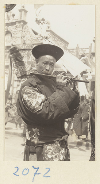 Musician playing a flute in a wedding procession
