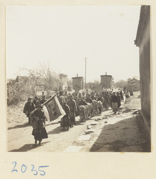 Man carrying a flag leading a wedding procession