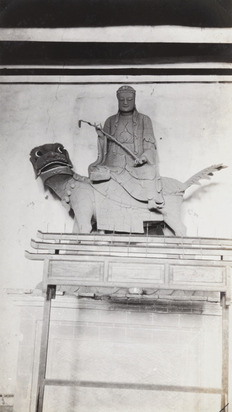 Wooden temple statue of Buddha riding a lion