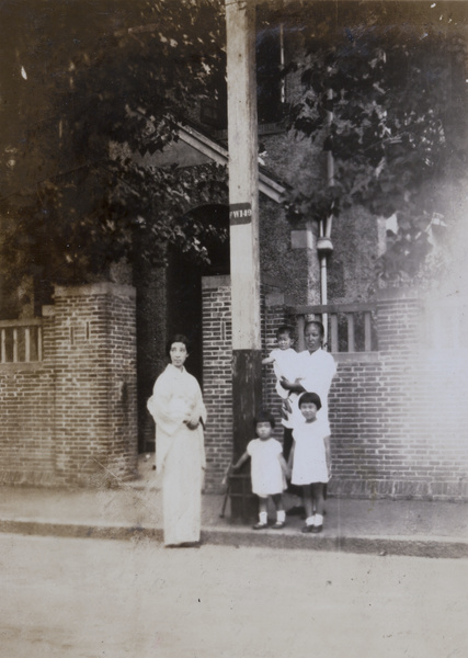 Two women with three children standing on the pavement in front of a house in North Sichuan Road, Shanghai (上海)