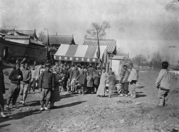 People gathered around a Baptist gospel preaching tent