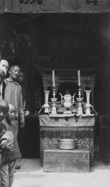 Men and children beside a coffin shrine