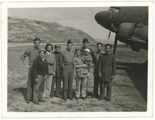 Hsiao Li Lindsay (李效黎) and baby Erica Lindsay, with others, beside a Douglas C-47 Skytrain (Dakota), after the arrival at Yan'an (延安) of the U.S. Army Observers Section, 1944