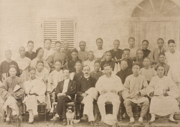 A group of unidentified Chinese men with three foreigners and a dog