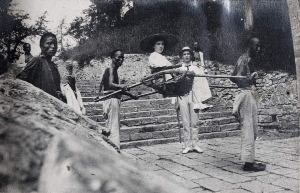 A foreign woman in a sedan chair and her bearers