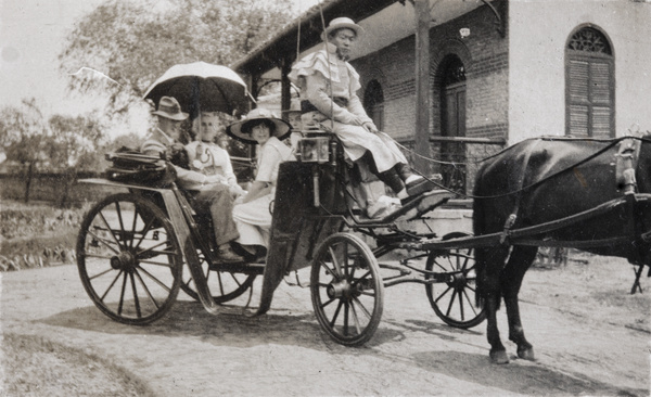 A group in a carriage with a uniformed driver