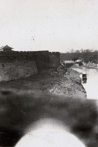 City wall and tower by a waterway