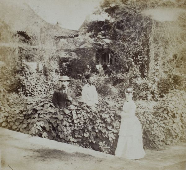 Albert Pirkis and Bessie L'Evesque Pirkis in a garden, with a Chinese man, British Legation, Beijing