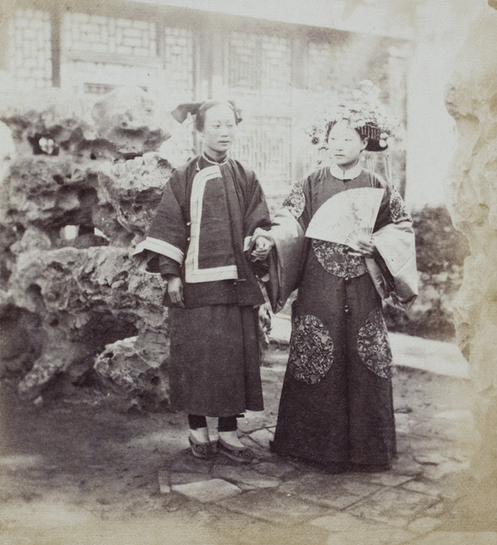 A Manchu bride in her wedding clothes, with her maid, in a rock garden (one of Yang Fang's courtyards) Beijing