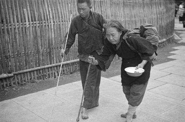 Blind young man and old woman with begging bowl, Shanghai