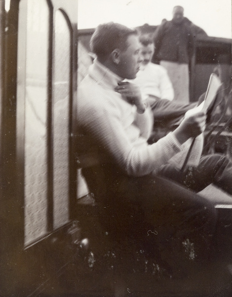 John Sullivan reading newspaper on board the SMP houseboat 'Kathleen'