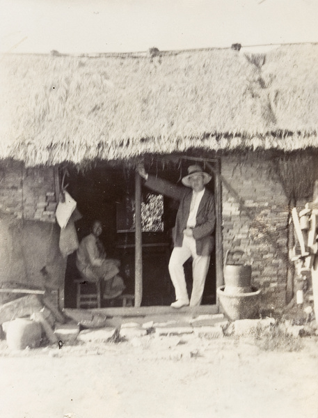 John Sullivan in the doorway of a workman's dwelling