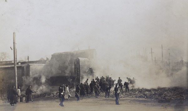Raking over smouldering remains after a fire (Peking Mutiny), Peking 1912