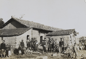 Labourers and children in front of a building