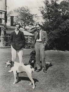 Two men with dogs in a garden