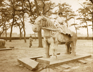 Woman posing on a stone horse at the Tomb of the Princess, Peking