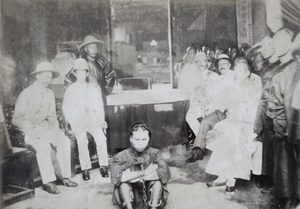 A Chinese prisoner in chains sitting in front of the county magistrate and a few Europeans