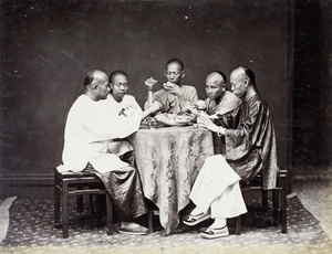 Studio photograph of men sharing a meal around the table, Hong Kong