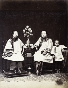 Studio photograph of two women and a child in Manchu style clothing, Hong Kong 