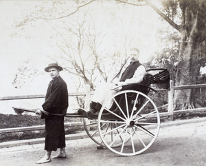 Two European men dressed in Chinese clothing as rickshaw man and passenger