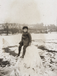 Marjorie Ephgrave sitting on snow mound, Public Garden, Shanghai, January 1931