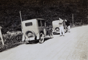Two men and two cars at the side of a road