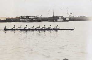 Men's eight rowing past houseboats on the Huangpu river