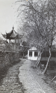 A cobbled riverside road and ornate pavilion