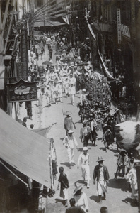 A procession passing through a commercial street, Hong Kong