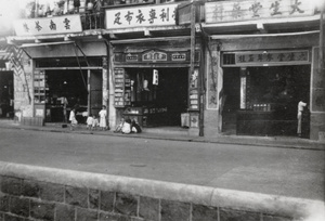 Children in front of a teahouse and medical provisions shop, Hong Kong