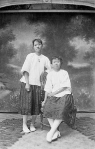 Two women, with a bucolic studio backdrop