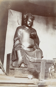 A shrine with Buddha holding a lotus flower