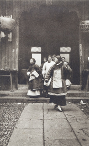 Older women with bound feet stepping into a temple courtyard
