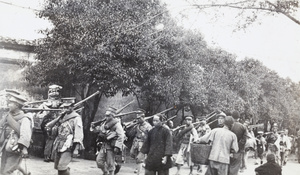 Nationalist soldiers on the move, passing a stone lion (石獅) and trees