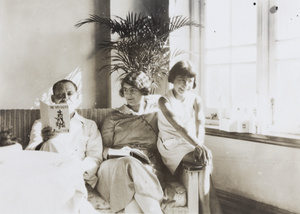 Felix Hookham reading ‘The Specialist’ by Charles Sale, beside his wife and daughter,  Repulse Bay Hotel, Hong Kong