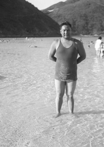 Unidentified man, wearing a bathing costume, in the shallow water of a bay, Hong Kong