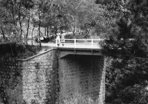 Bea and Gladys Hutchinson on a day trip, standing on a bridge over a ravine, Hong Kong