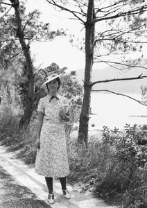 Bea Hutchinson standing at the side of a road above a Castle Peak Road beach, Hong Kong