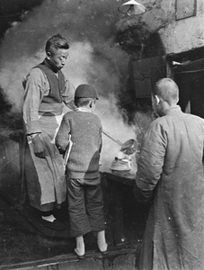 A man filling a kettle for a boy carrying a newspaper, in a hot water shop (old tiger stove shop or laohuzao), Shanghai