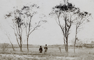 Fred and Dick Hutchinson looking over a field towards grave mounds, Hongkou, Shanghai