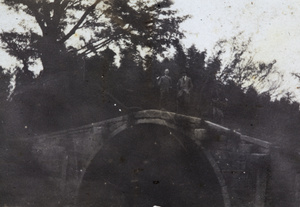 George Danson and John Piry, with hunting rifles, on a stone bridge with an unidentified man