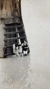 Women in bathing costumes sitting on the steps of a wooden water pylon, Shanghai