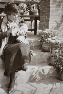 Hannah holding a cat and sitting on the verandah steps, 35 Tongshan Road, Hongkou, Shanghai