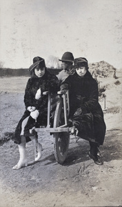 Two young women sitting on a wheelbarrow, Wusong, February 1920