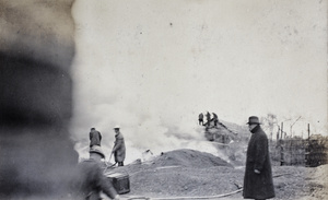 Police detective standing by while firemen attend a large fire on the day of Chinese New Year, Shanghai, February 1920