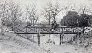 Two young women sitting on a wooden bridge, Jessfield Park, Shanghai